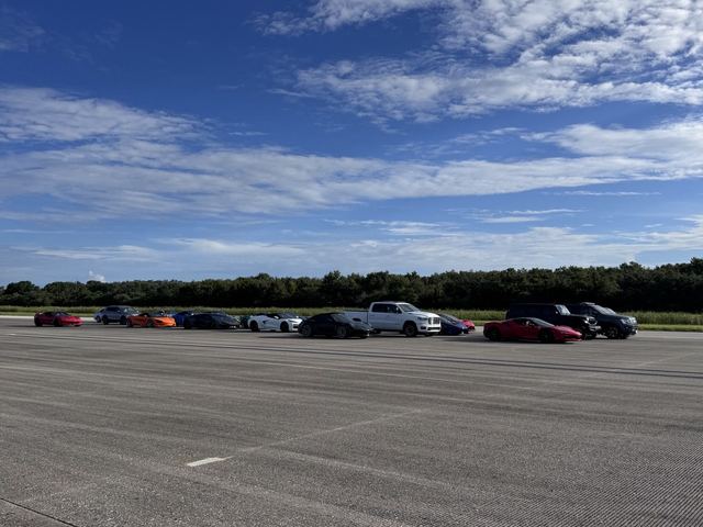 A line of high-performance sports cars staged on the concrete runway.