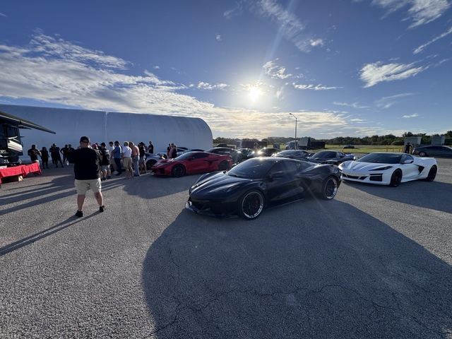 Black, red and white sports cars on display at the outdoor event.