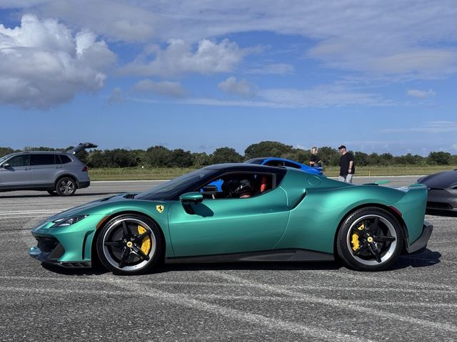 A turquoise sports car on display at the outdoor event.