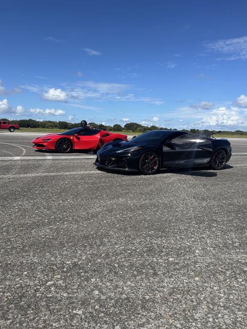 A red sports car and a black sports car parked side by side.