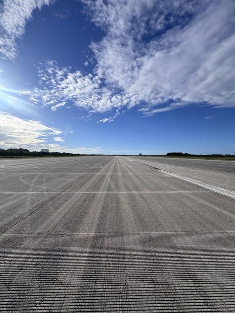 Low view down the empty grooved concrete runway.