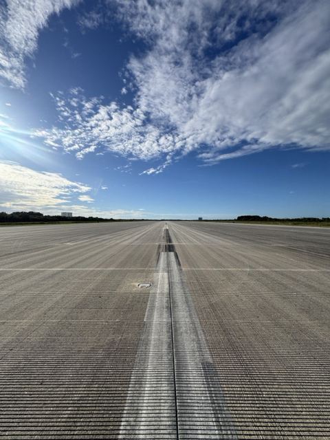 Looking down the long grooved runway toward the horizon.