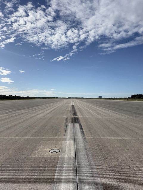 The empty concrete runway reaching to the horizon.